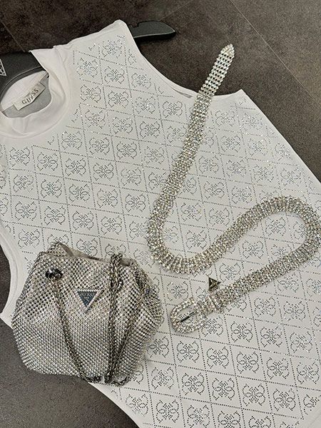 Een zilver avondtasje van Guess met strass stenen met een bijpassende witte Guess top en een zilveren Guess riem.